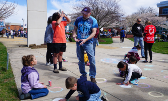 students and kids drawing with chalk